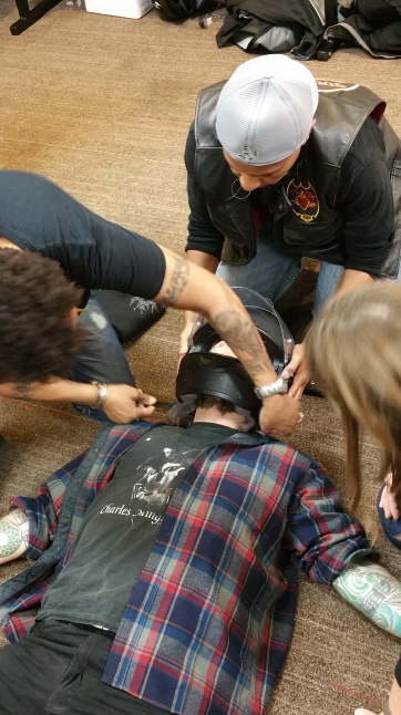 Members of Soul Fire practice a two-person helmet removal technique.